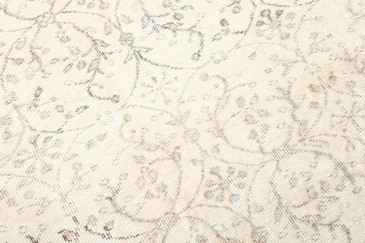 Close-up of the hand-knotted wool pile, highlighting the faded and distressed look of the rug's pattern.