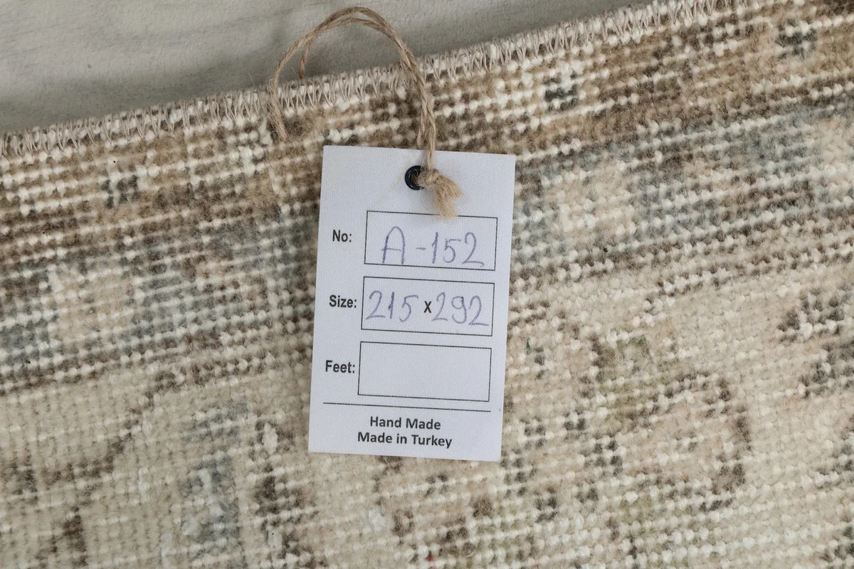 Tag attached to the rug displaying its size 215x292 cm and origin 'Hand Made Made in Turkey'.