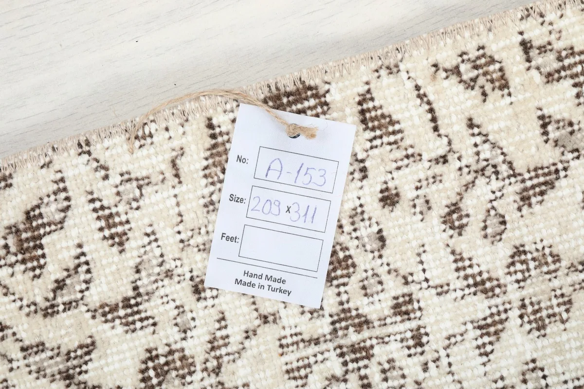 Underside view of the rug, showing the cotton foundation and a size tag