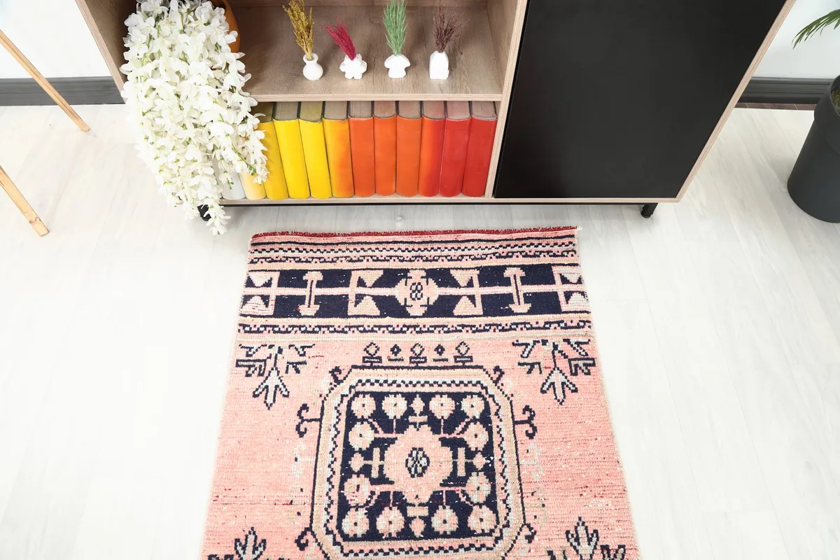 View of one end of the runner rug, showing the navy border and the start of the rose field