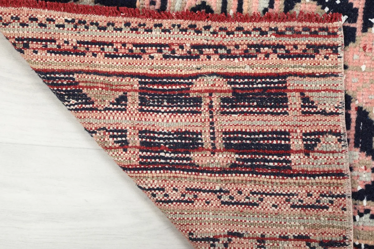 Underside view of the runner rug, revealing the cotton foundation and knotting structure