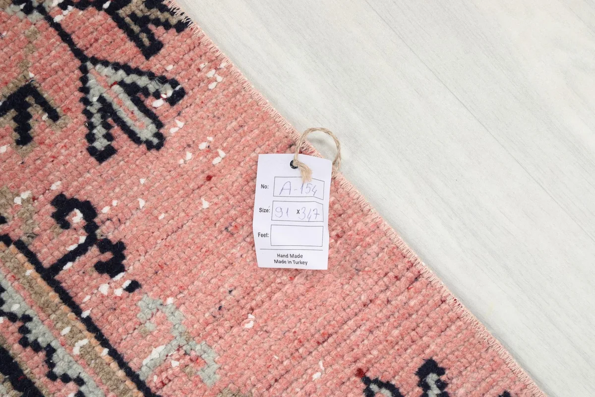Corner of the runner rug with a product information tag, showing 'Hand Made in Turkey'