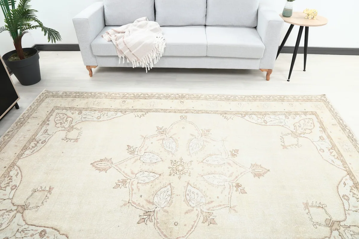 Overhead view of the vintage cream rug, showing the central medallion and surrounding room elements