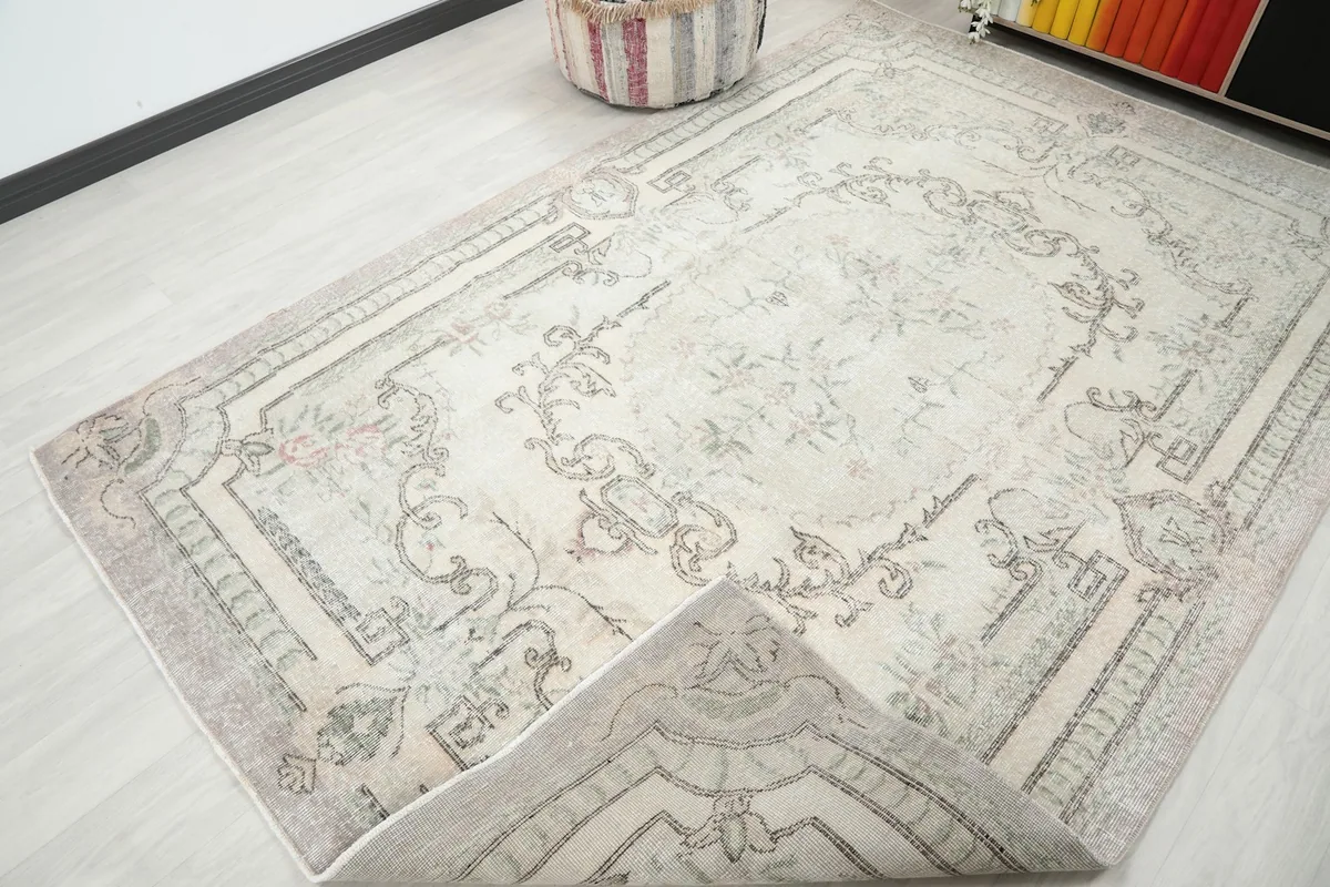 View of the rug with a corner folded back, revealing the hand-knotted cotton foundation.
