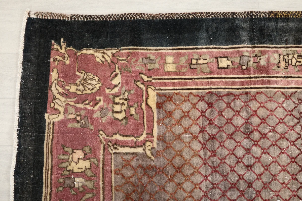 Detail of the charcoal border and corner motif of the vintage rug