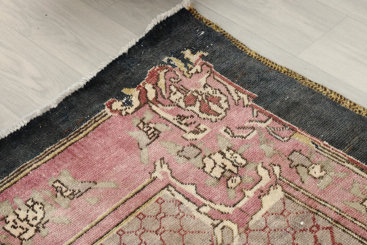 Close-up of a corner, showing the distressed charcoal border and motifs