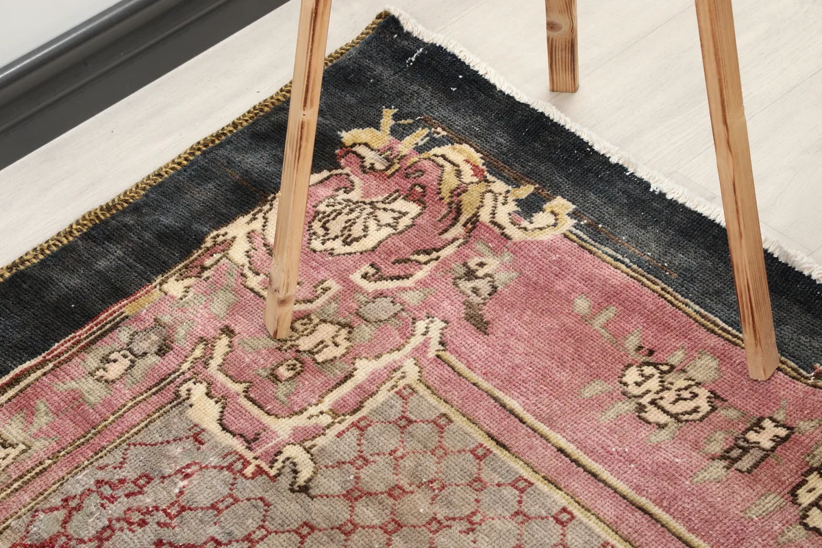 Another close-up of a rug corner with table leg, highlighting texture and color