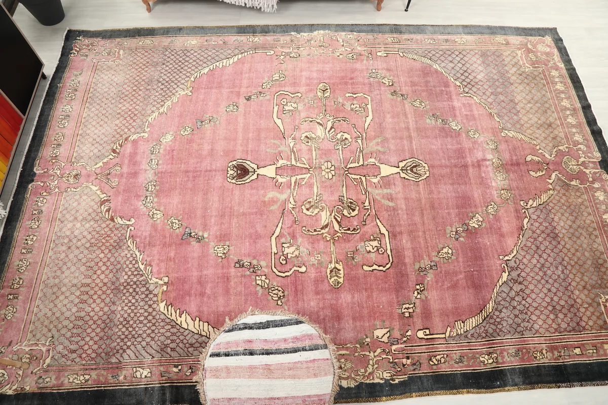 Rose Medallion Anatolian Area Rug displayed in a room setting with a pouf