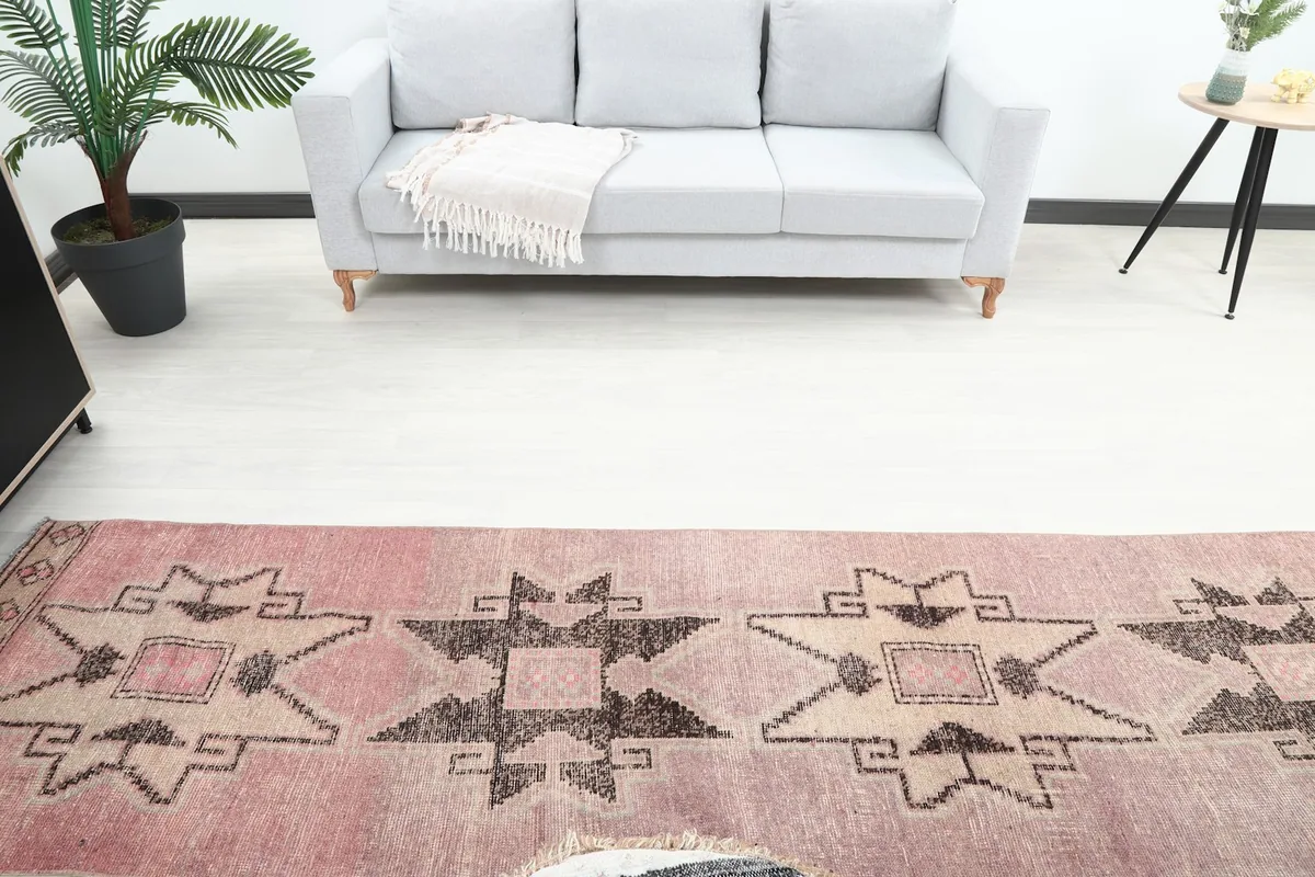 Overhead view showing the middle section of the runner rug and a couch in the background.