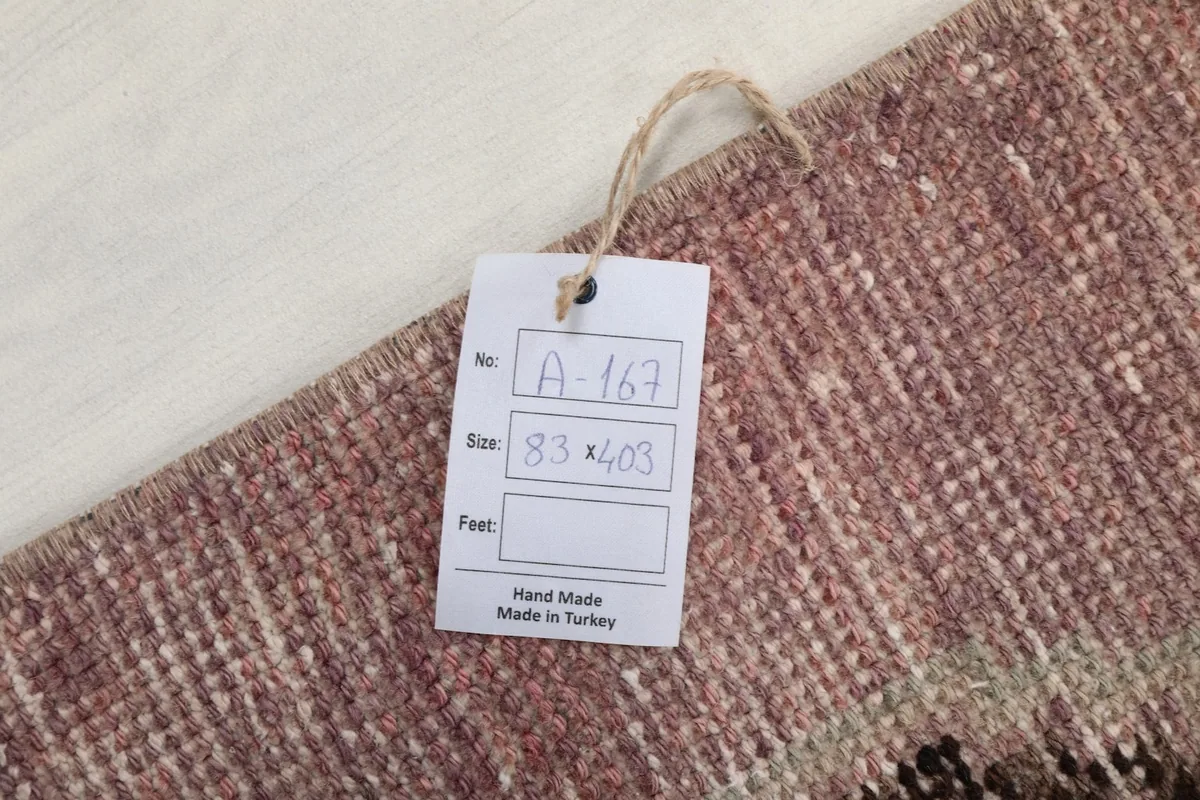 Tag attached to the rug, showing the dimensions in centimeters (83 x 403 cm) and indicating hand-made in Turkey.
