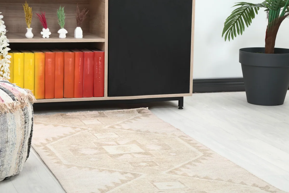 Detail of the runner rug's geometric pattern near a wooden cabinet with colorful books