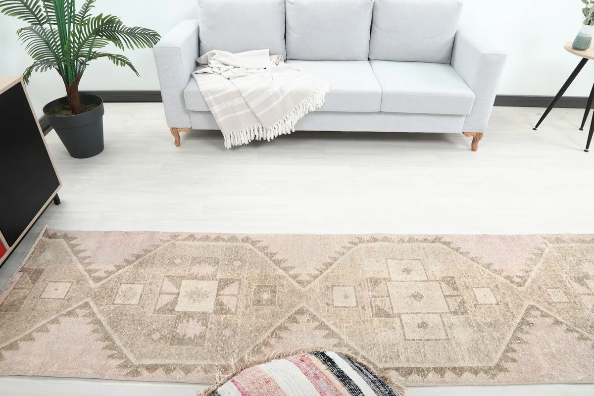 Overhead view of the vintage runner rug in a room, showing its length and placement by a sofa