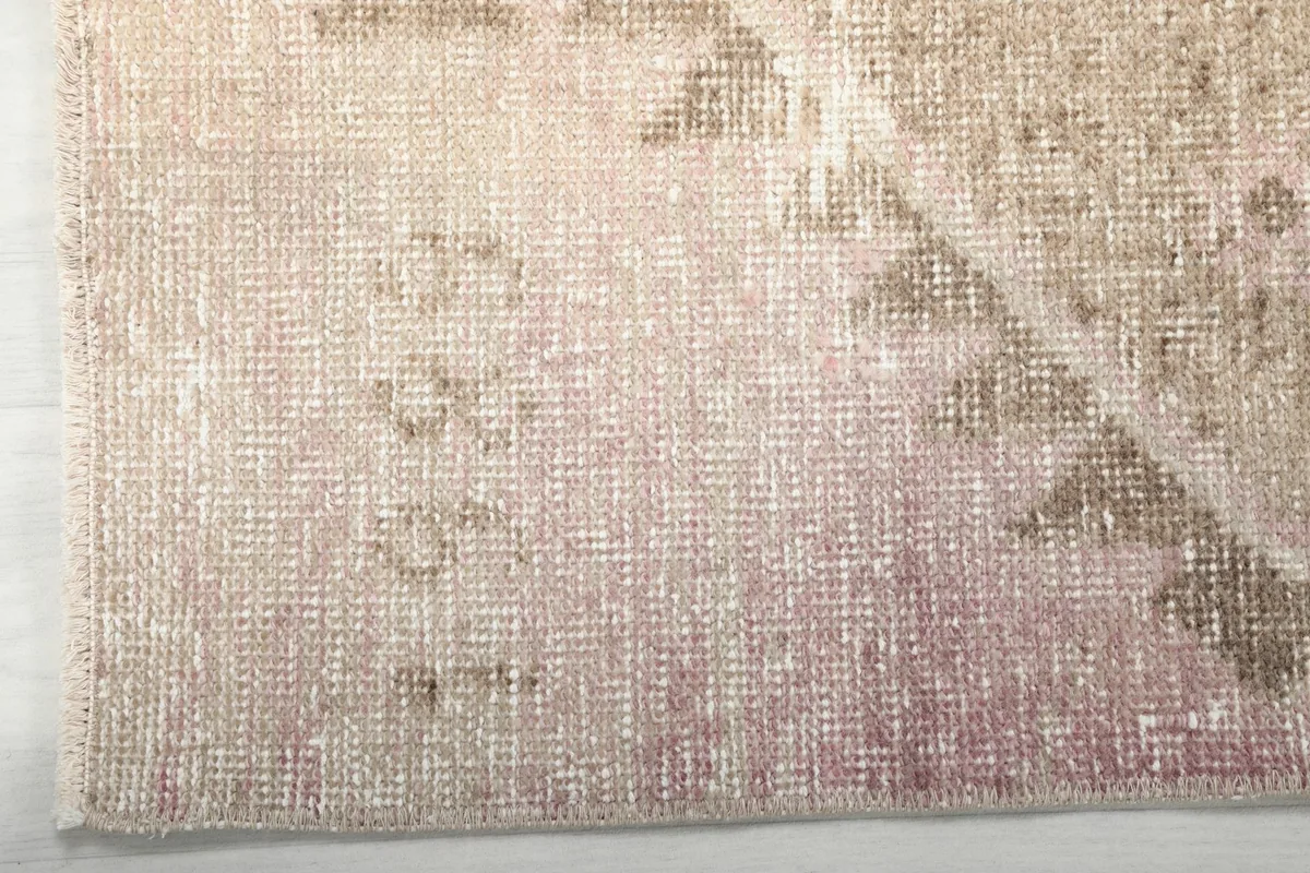 Side view showing the low pile height and soft texture of the vintage wool rug