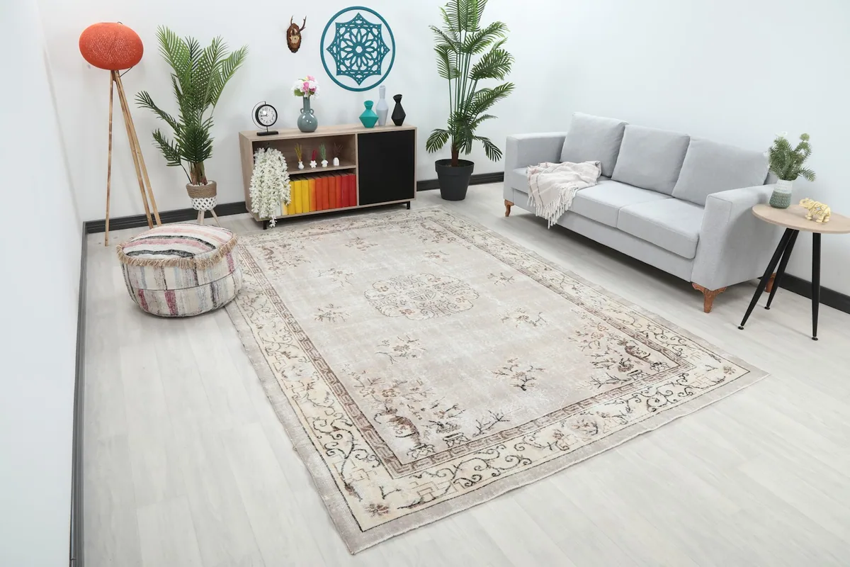 Angled view of the beige Chinoiserie medallion rug in a living room, showing its full scale