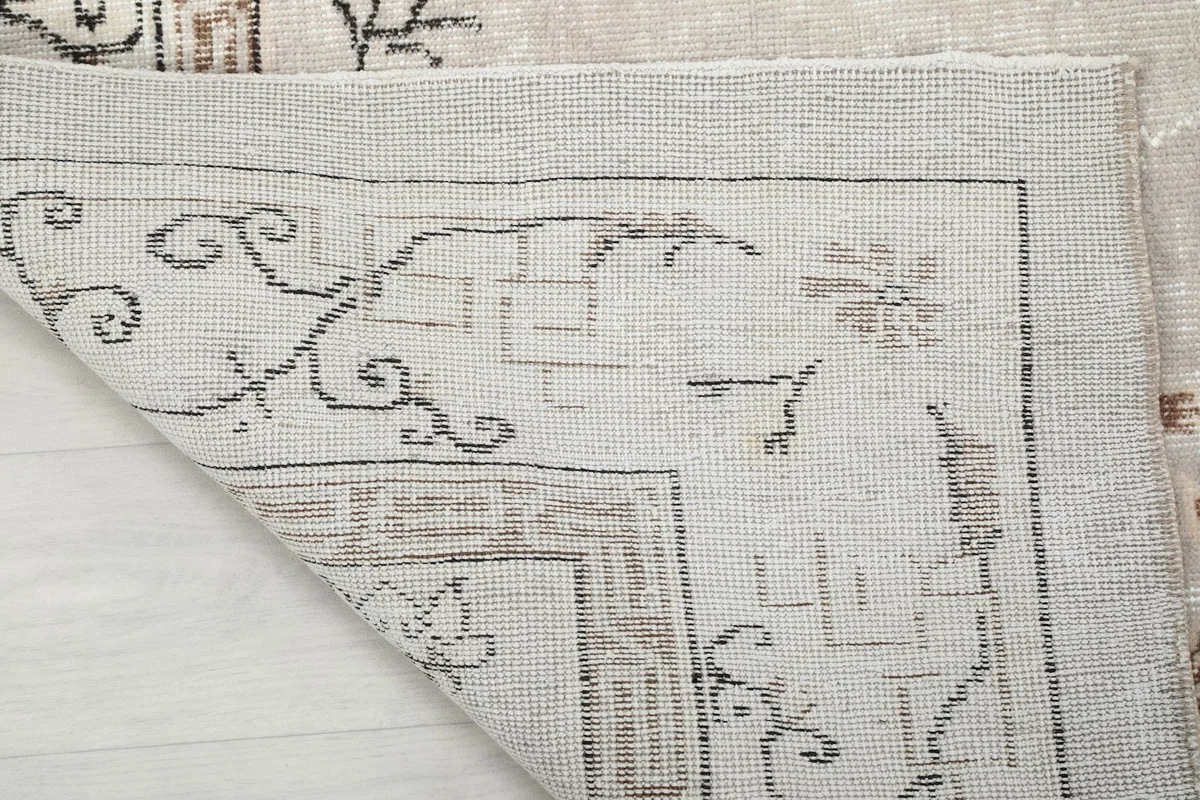 Close-up of the rug's reverse side, showing the hand-knotted cotton foundation and knotting
