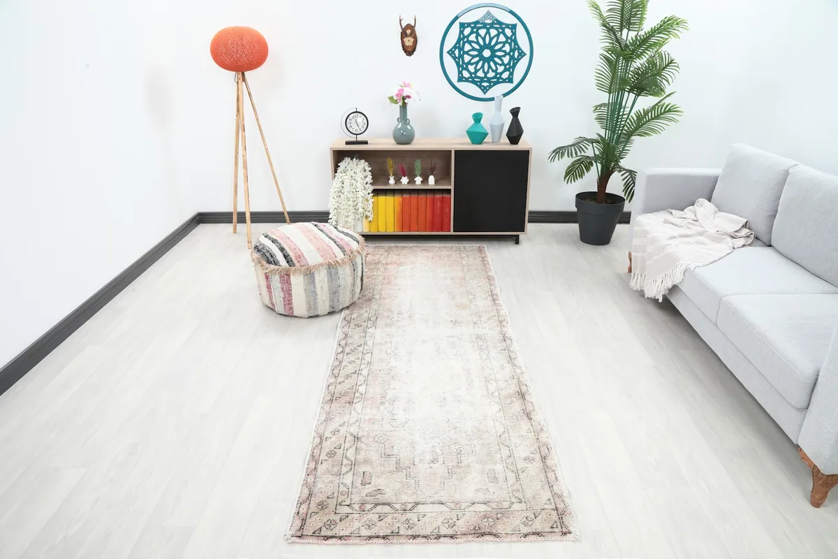 Long view of the rose and ivory runner rug in a modern living space with a gray sofa