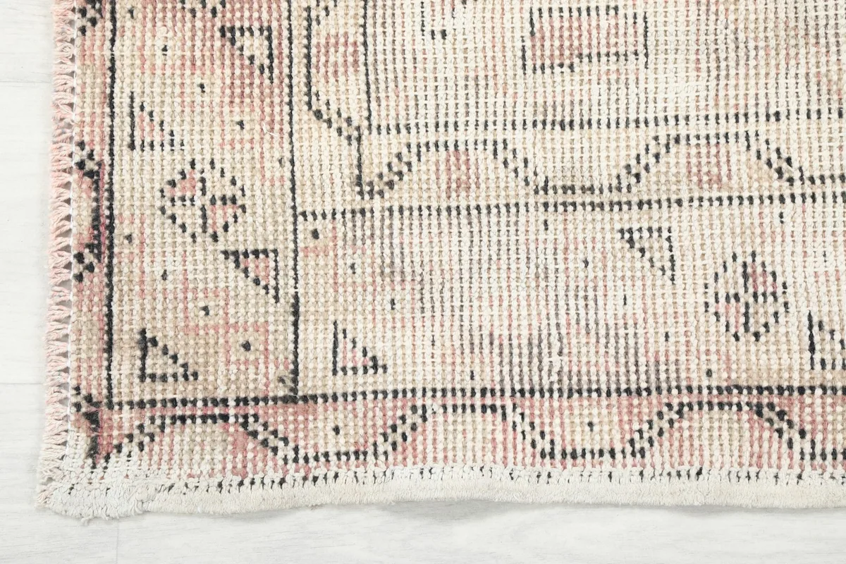 Close-up of the rug's border and corner, revealing the intricate geometric knotting