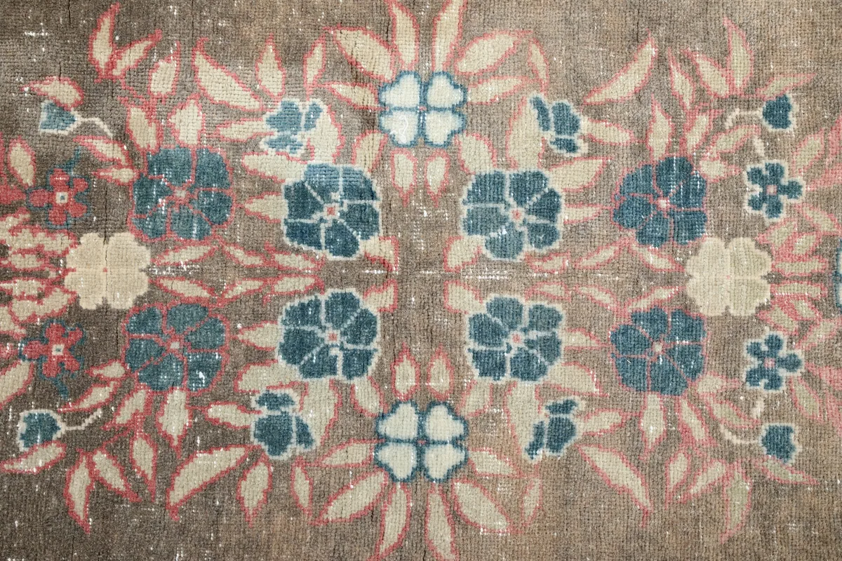 Detail of the central floral cluster on the Gray Rose Medallion Anatolian Rug, featuring blue and cream tones.