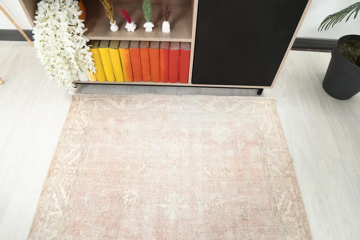 View from above showing the rug's top edge and faded pattern near a console table