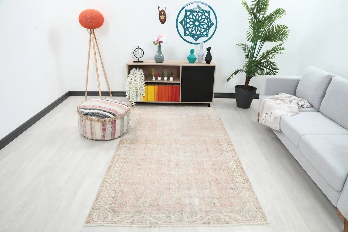 Vintage rose beige rug placed in a modern living room setting with a light gray couch