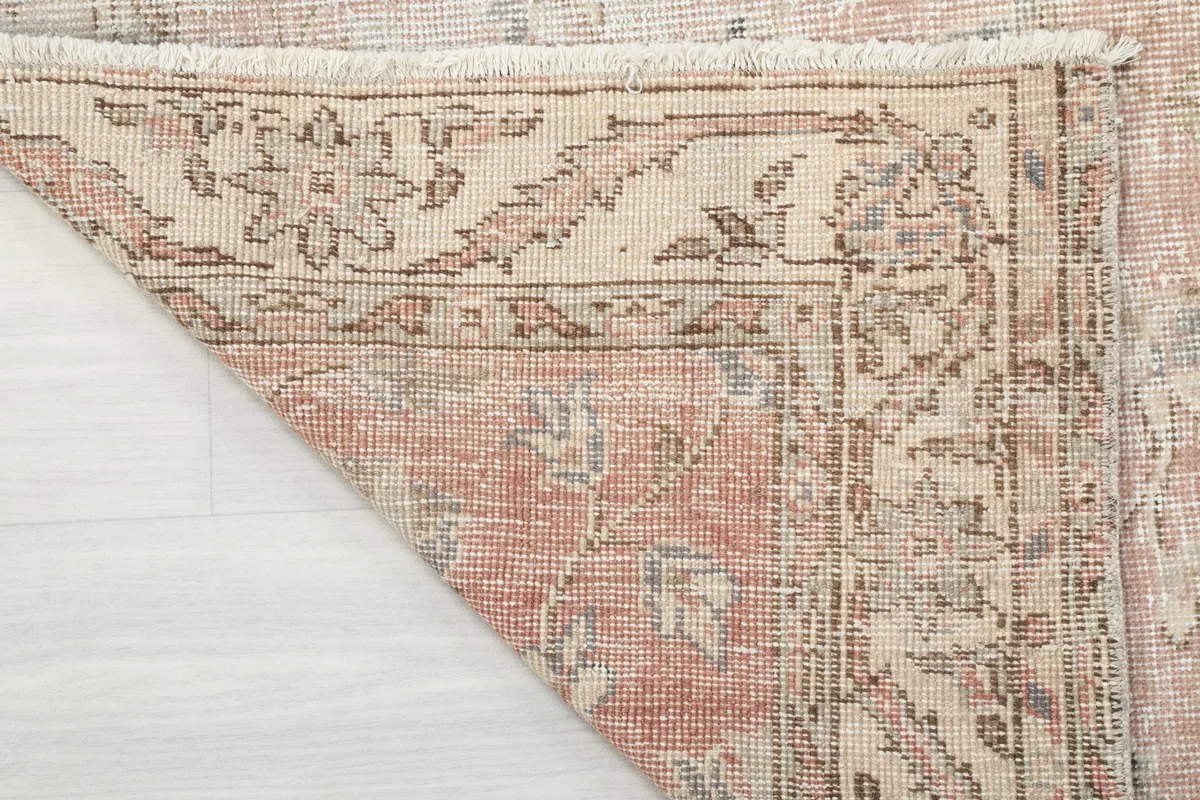 View of the rug's underside, revealing the hand-knotted cotton foundation and wool pile
