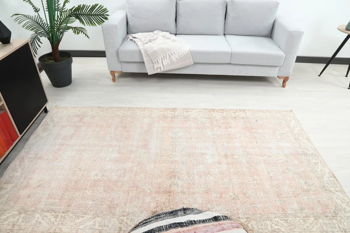 Overhead view of the rug in a room, highlighting its medium size and faded colors