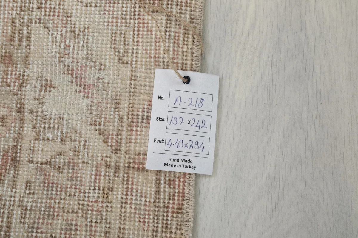 Label attached to the rug, showing its dimensions in centimeters and feet, and origin