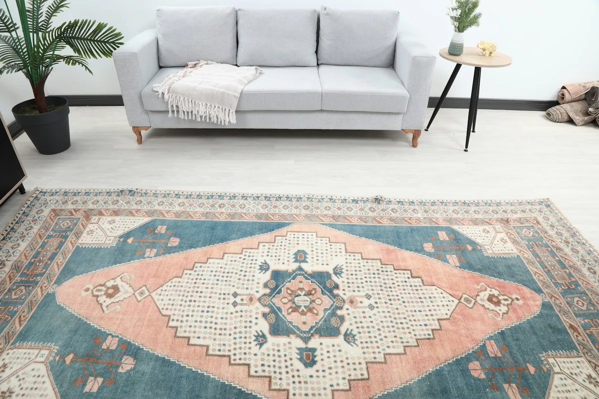 Overhead angle of the vintage rug's central design, with a gray sofa in the background