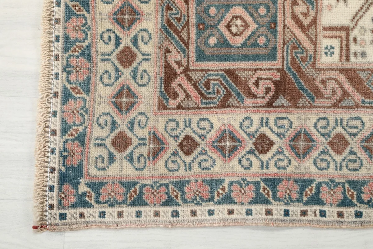 Detail of the rug's multi-layered border with geometric and floral-inspired patterns