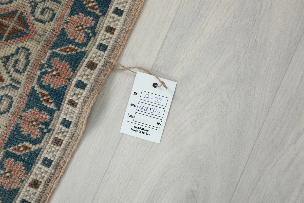 Product tag indicating the rug's dimensions and origin, placed on the light floor
