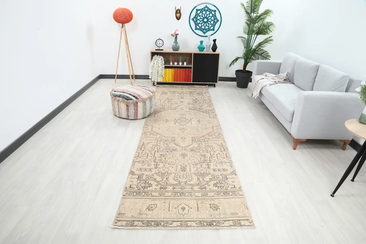 Full room view of the beige and brown runner rug stretching along a hallway or living space.