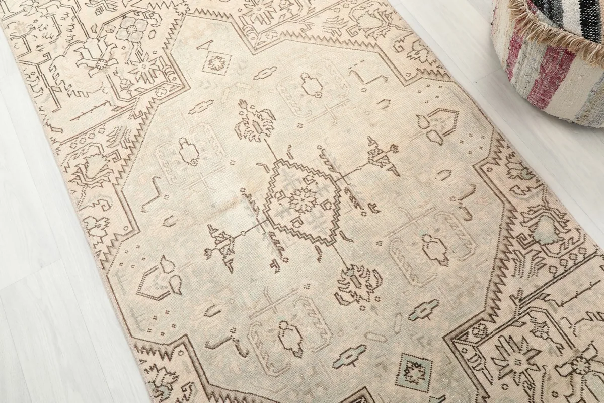 Detailed angled shot of the central medallion and surrounding geometric motifs on the beige runner.