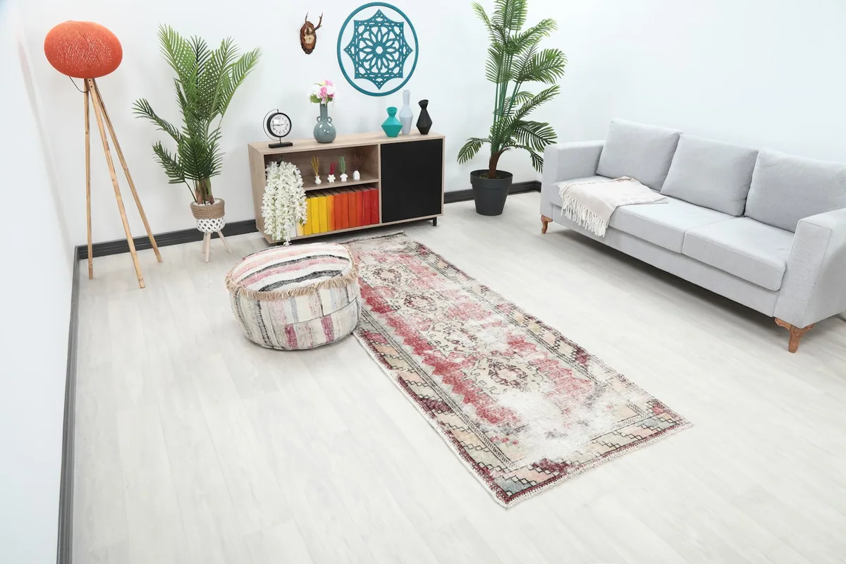 Angle view of the rose and cream runner rug in a room setting, showing its length and placement