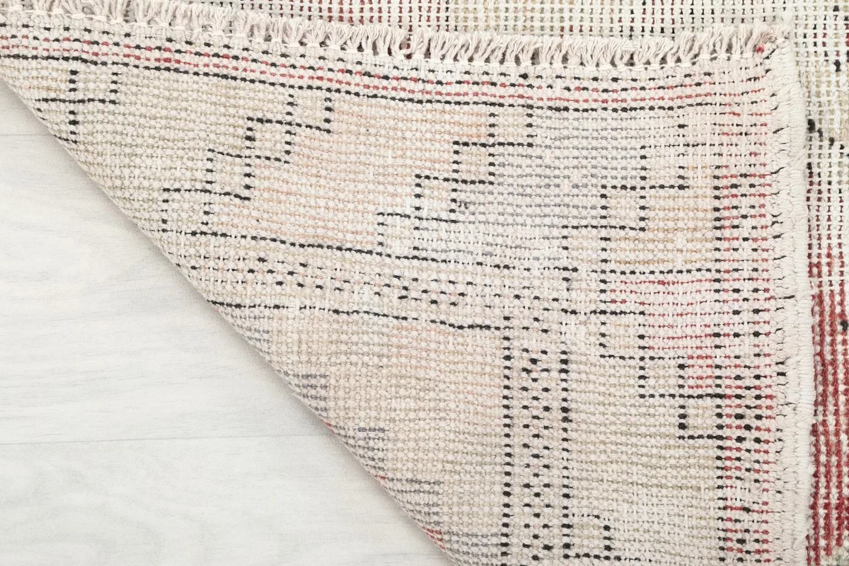 Underside of the runner rug, showing the cotton foundation and hand-knotted construction