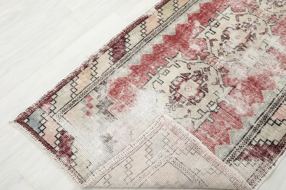 Corner of the runner rug folded back to reveal the back weave and fringe details