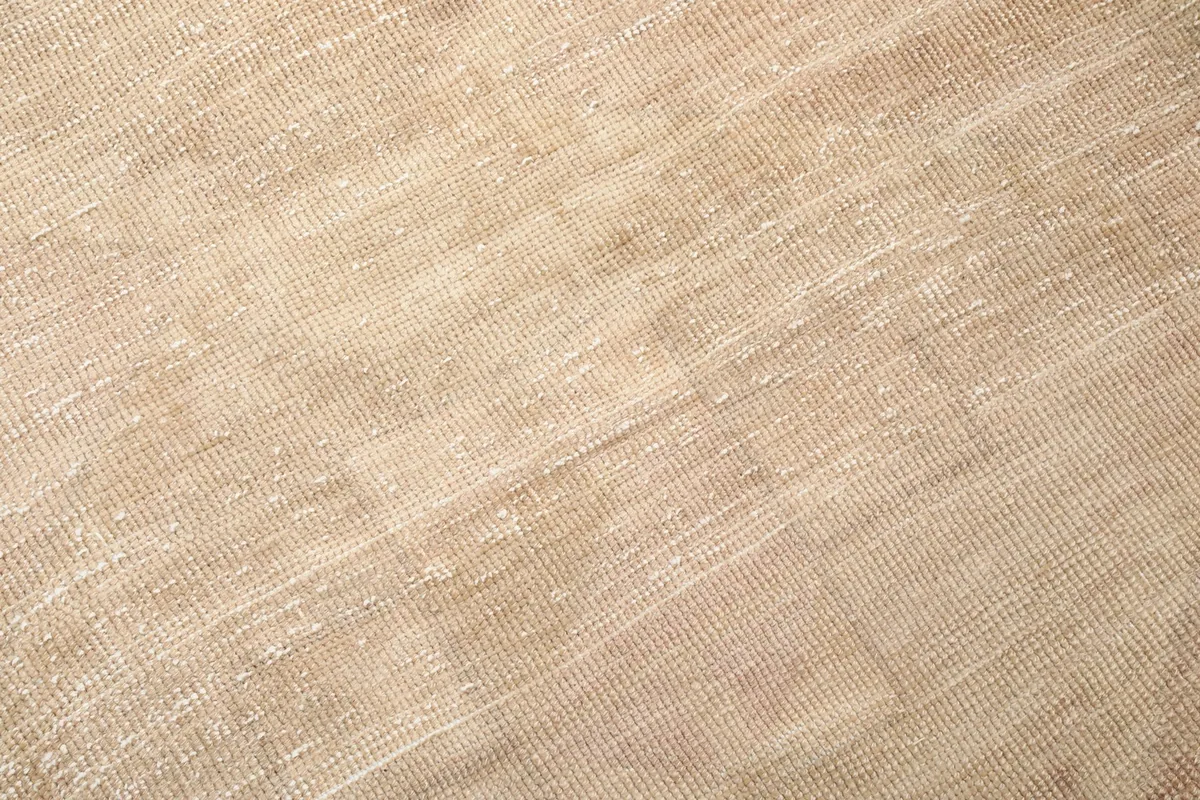 Tight close-up of the rug's low wool pile, showing the hand-knotted texture and fiber direction.