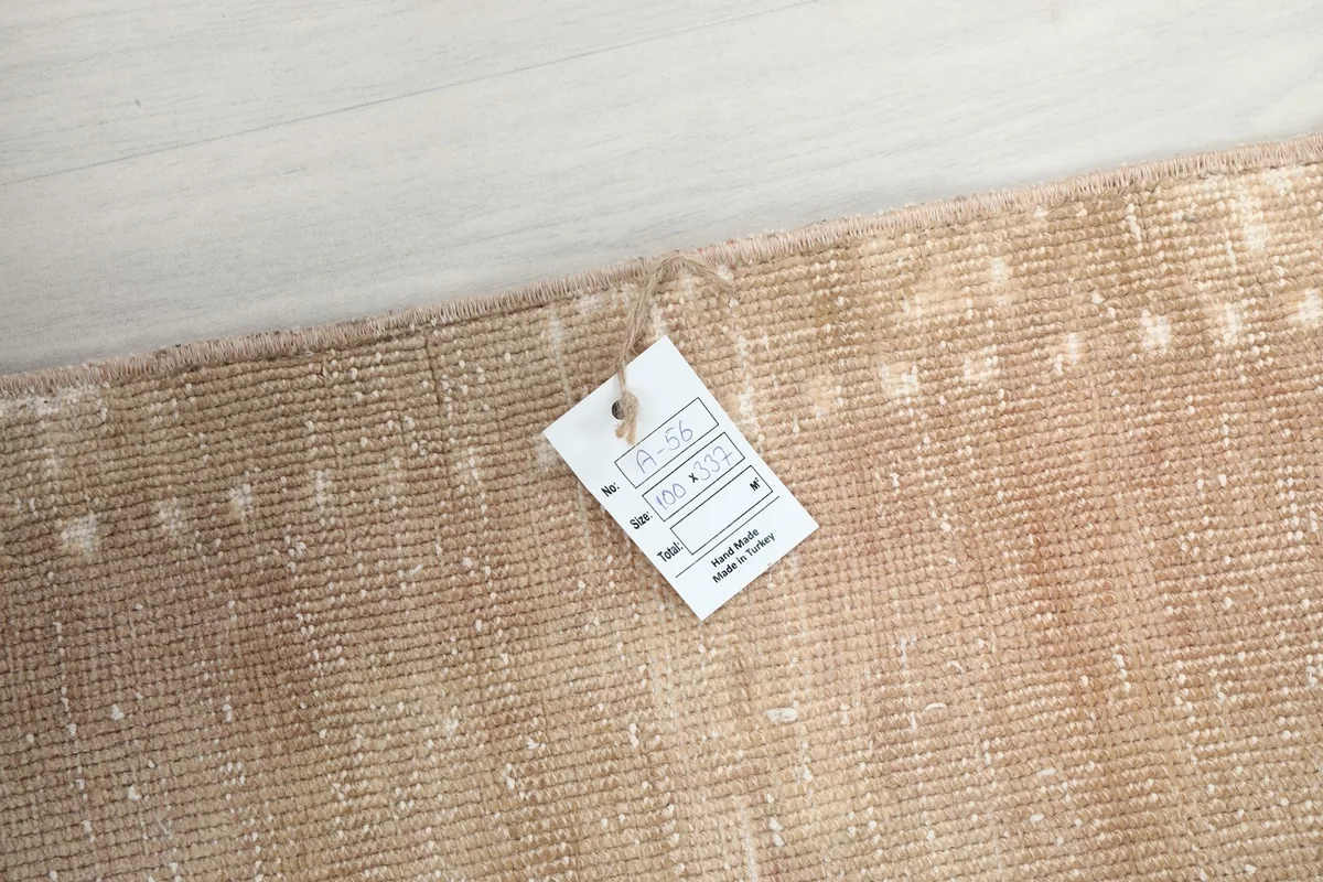 View of the rug with a product tag attached, showing the quality and origin information.