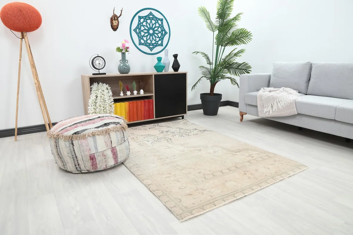 Overhead view of the ivory vintage rug in a living room with a sofa and ottoman