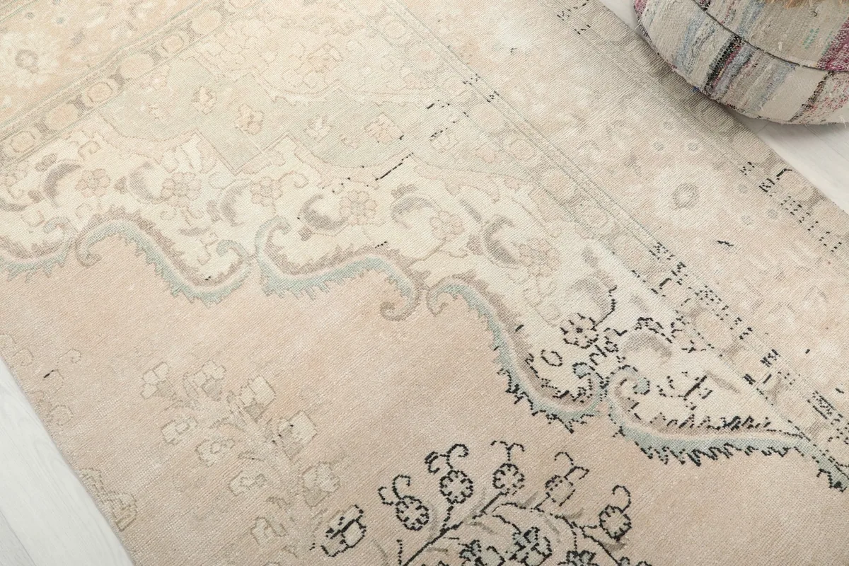 Close-up detail of the central floral medallion and border design on the rug