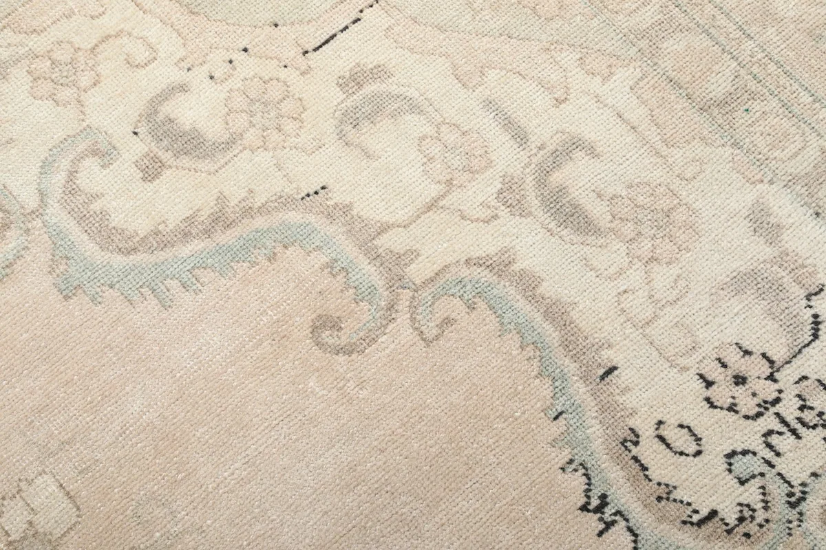 Detailed view of the intricate gray and blue patterns on the ivory rug