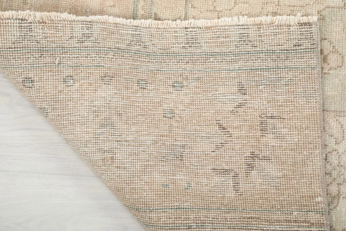 Underside of the hand-knotted wool rug, revealing the cotton foundation