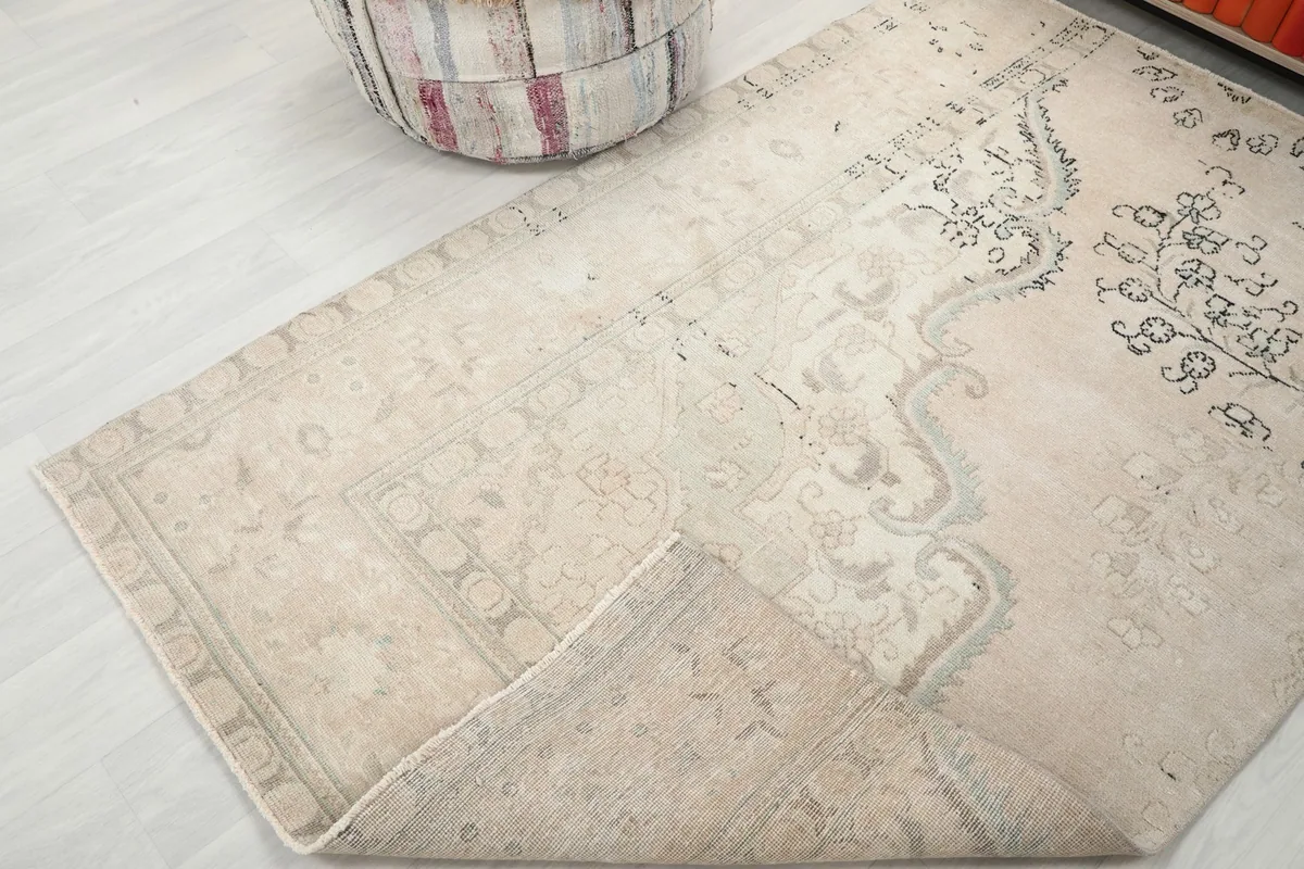 Corner of the rug folded to show the thickness and texture of the wool pile
