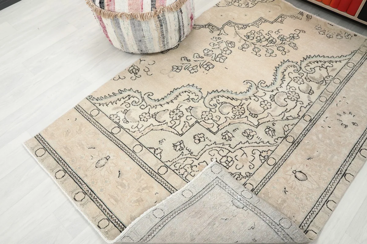 Angled view of the rug with one corner slightly lifted, revealing the back