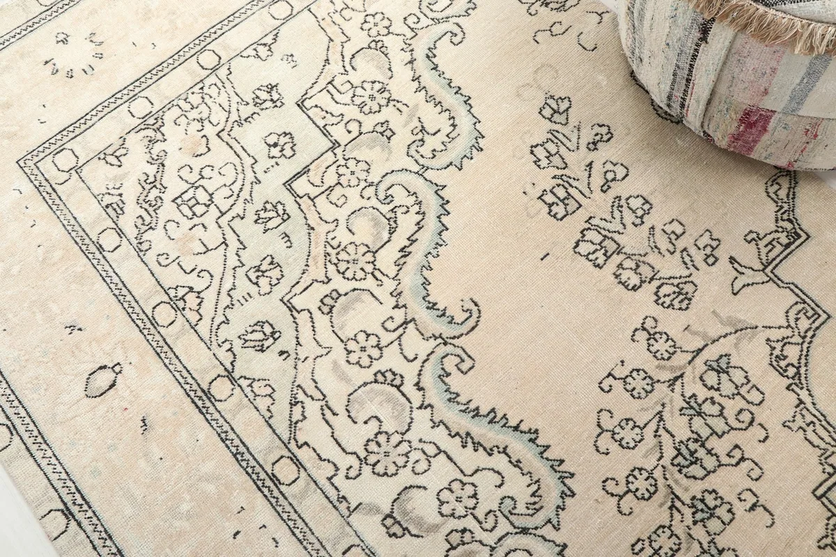 Detailed view of the charcoal floral and geometric motifs on the beige background