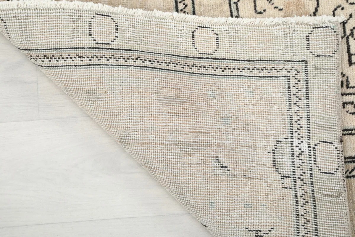 View of the rug's reverse side, showing the cotton foundation and hand-knotting