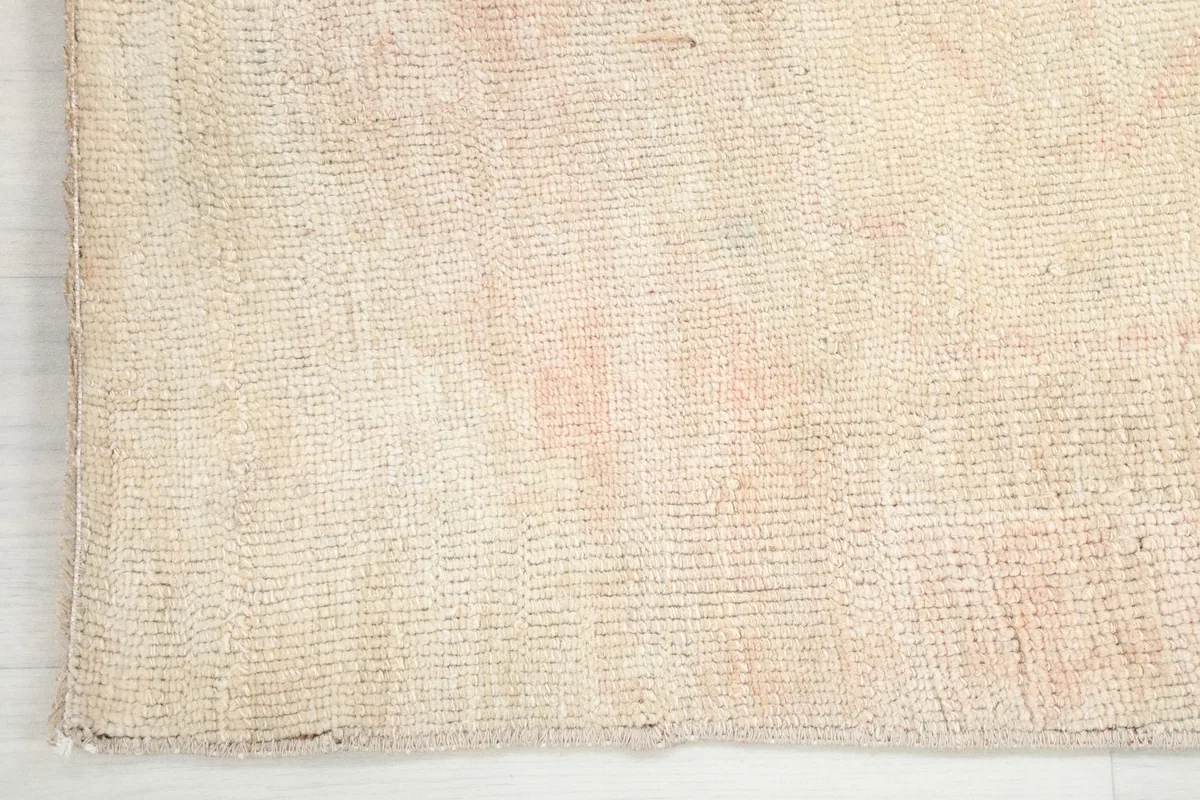 Edge of the runner rug, showing the hand-knotted construction and finished side