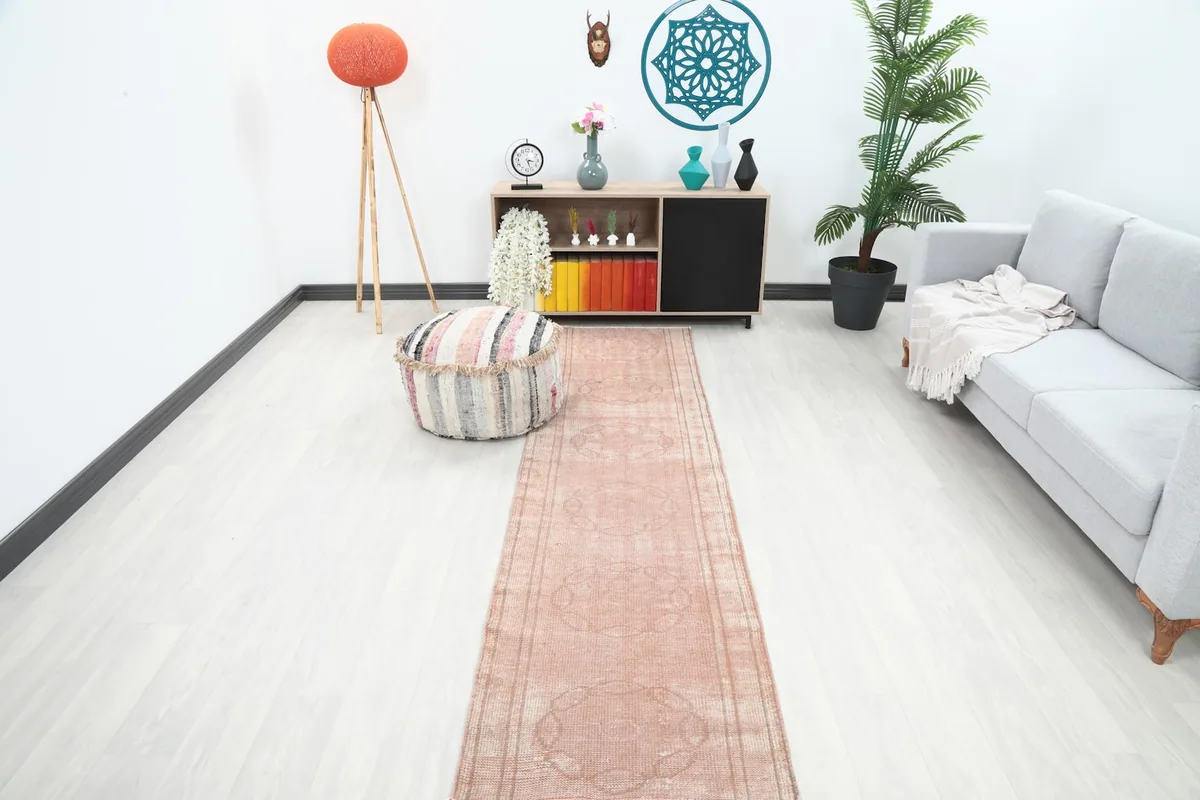 Vintage Anatolian rose runner rug displayed in a modern living room setting