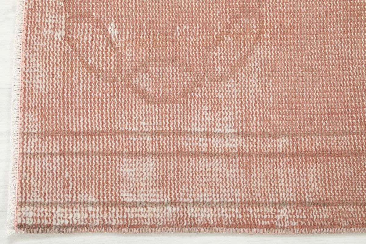 Detail of the rug's edge, showing the subtle border design and low pile