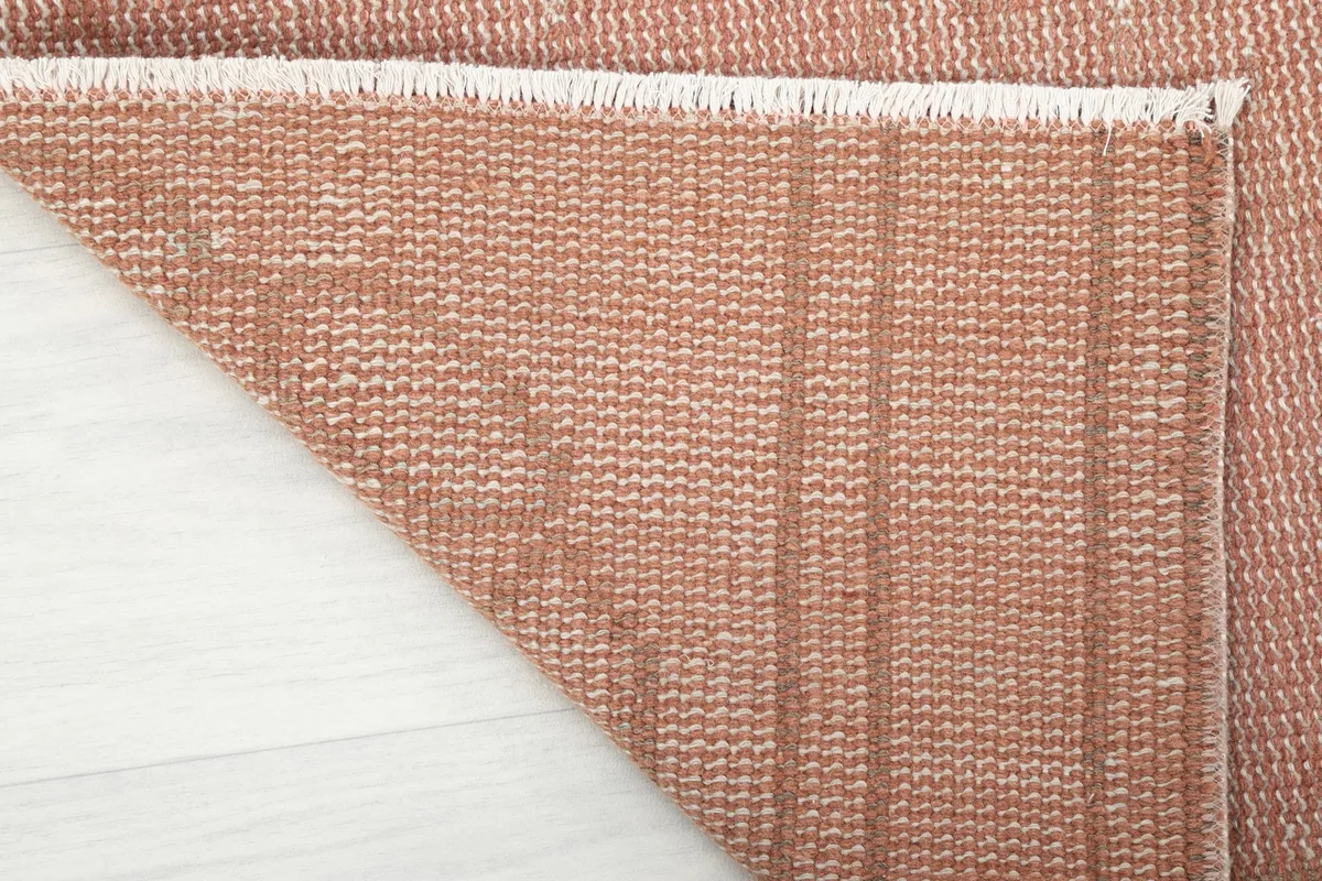 Underside view of the hand-knotted cotton foundation and wool knots of the runner rug