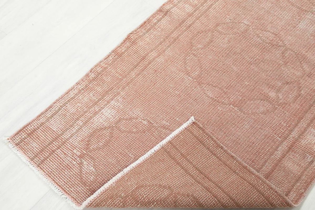 Corner of the rose runner rug folded to show the thickness and construction
